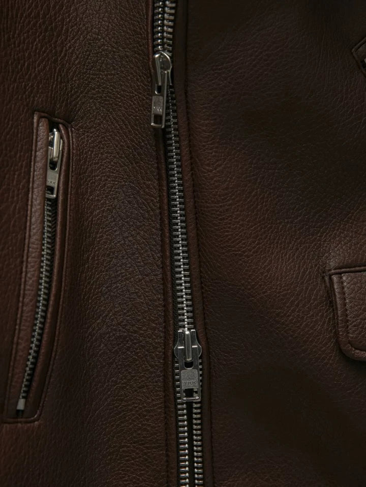 Close-up of a brown leather jacket with zippers