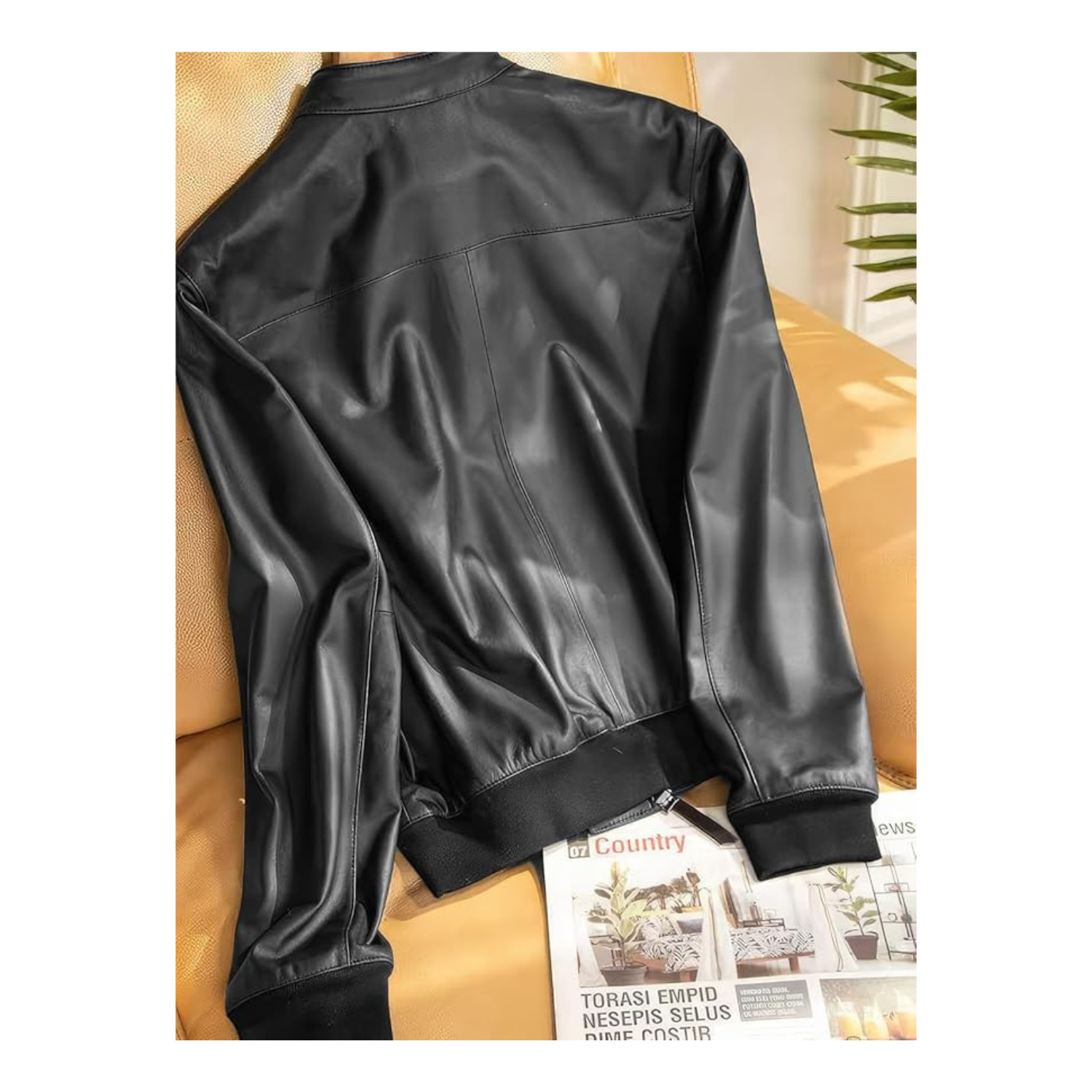Black leather jacket on a beige couch with a magazine underneath