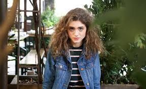 Model wearing ArnaLuxe Stranger Things-inspired varsity jacket with retro backdrop