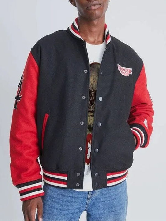 Model walking in city wearing ArnaLuxe black varsity jacket with streetwear outfit