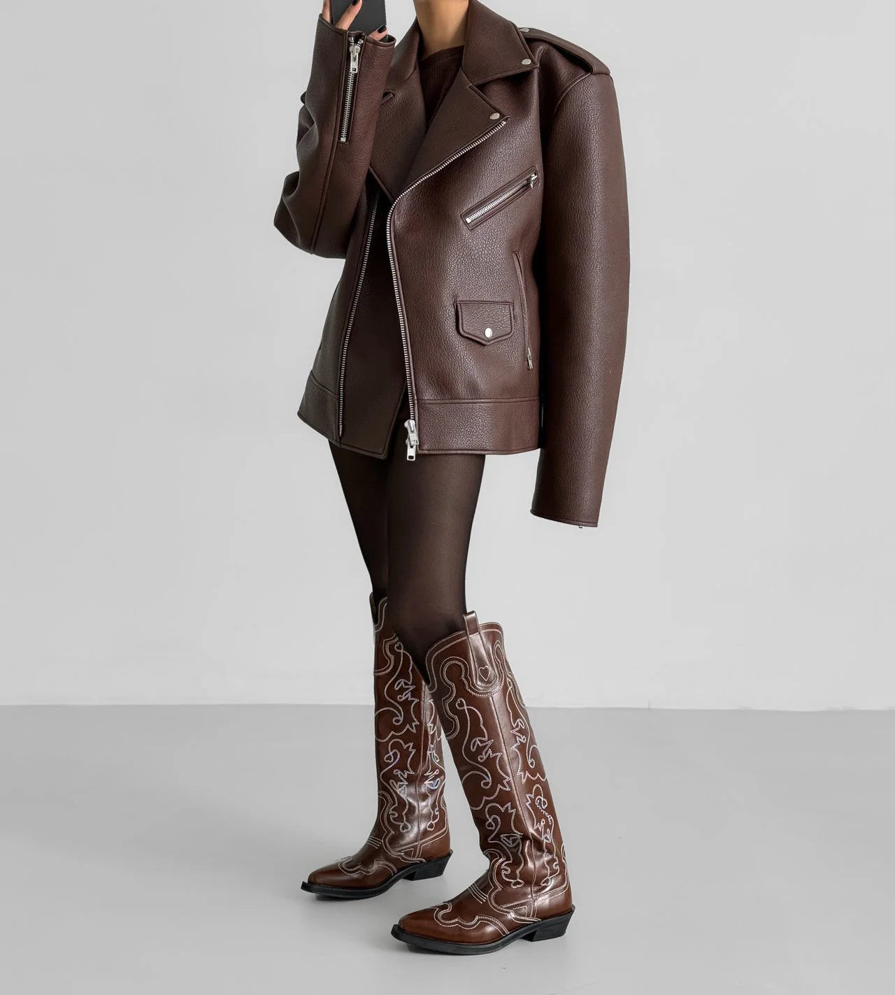 Brown leather jacket and boots on a plain background
