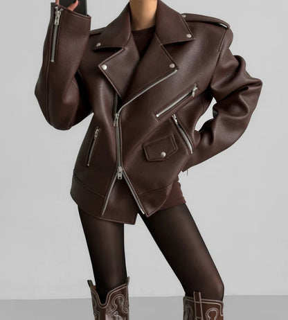 Brown leather jacket with zippers on a plain background